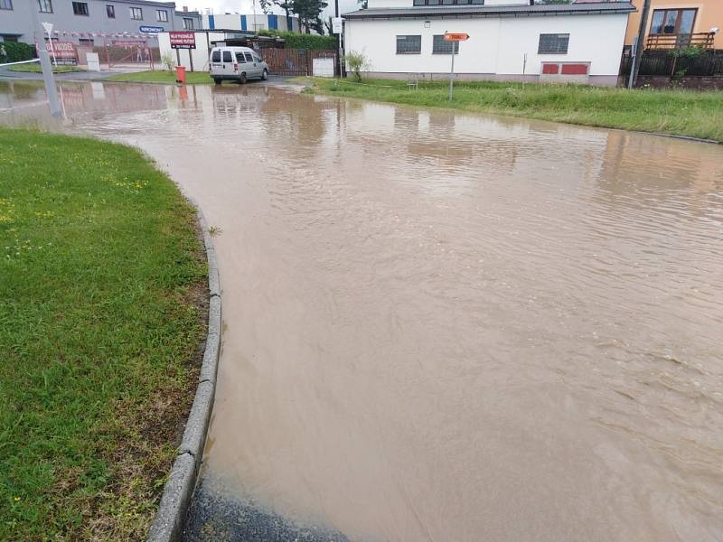 Zaplavená ulice v Klatovech u firmy Lorenc a Benziny ve směru na Luby. Voda teče proudem z pole.