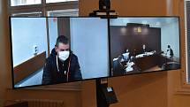 Soudní proces moderně, pomocí videokonference. Na obrazovce vlevo je obžalovaný sedící ve věznici v Plzni, vpravo je pohled do soudní síně v Klatovech.