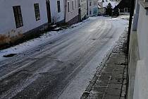 Silnice pokrytá ledem ve Velharticích před polednem.