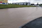 Zaplavená ulice v Klatovech u firmy Lorenc a Benziny ve směru na Luby. Voda teče proudem z pole.