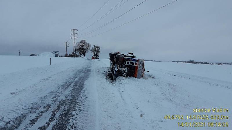 Na silnici mezi obcemi Zdislavice a Malovidy skončil kamion na boku. A o pár metrů dál i sypač, který se snažil vozovku zprůjezdnit.