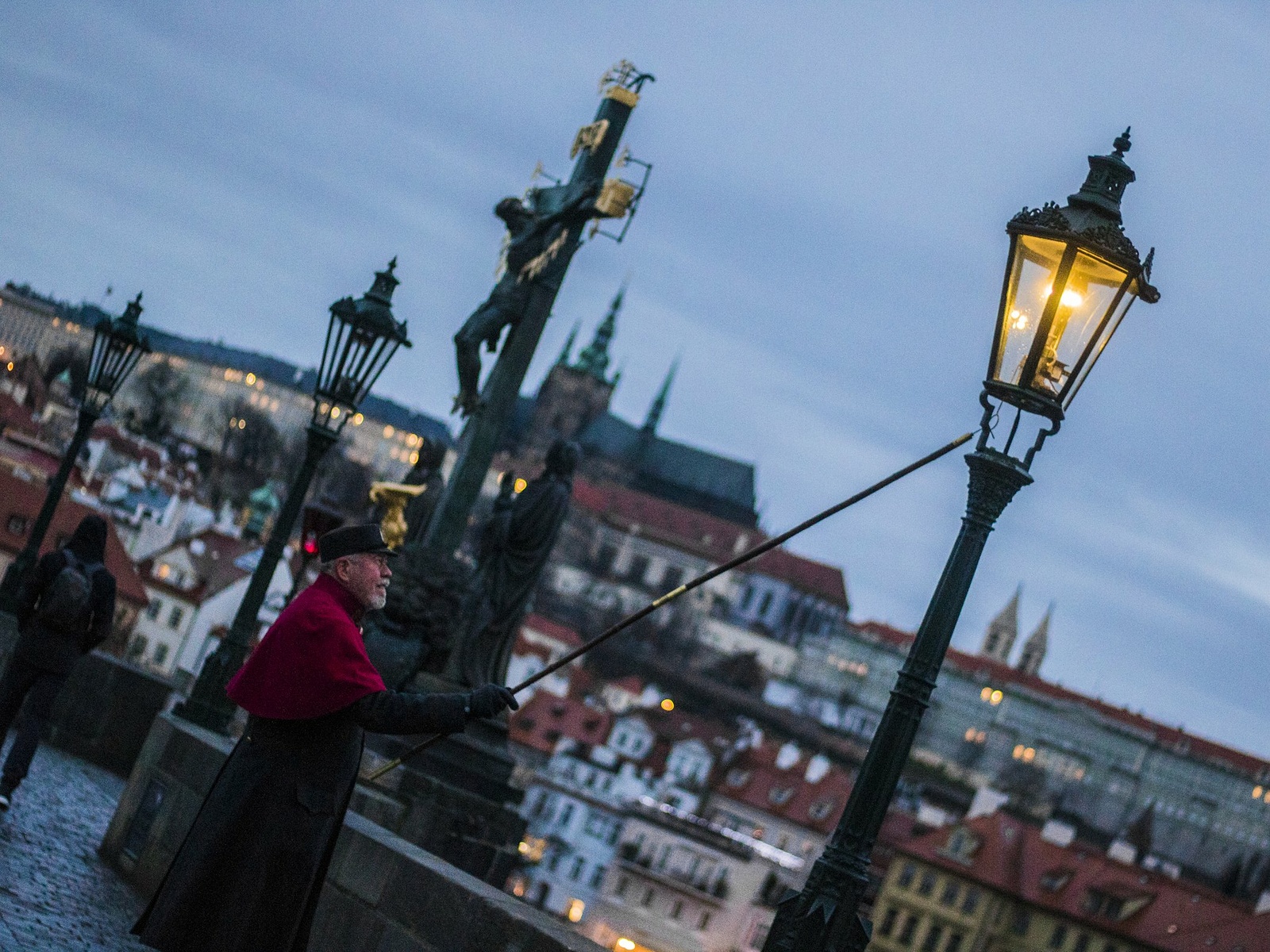 OBRAZEM: Lampář vyrazil na Karlův most. Každý den rozsvěcí 46 plynových  luceren - Pražský deník