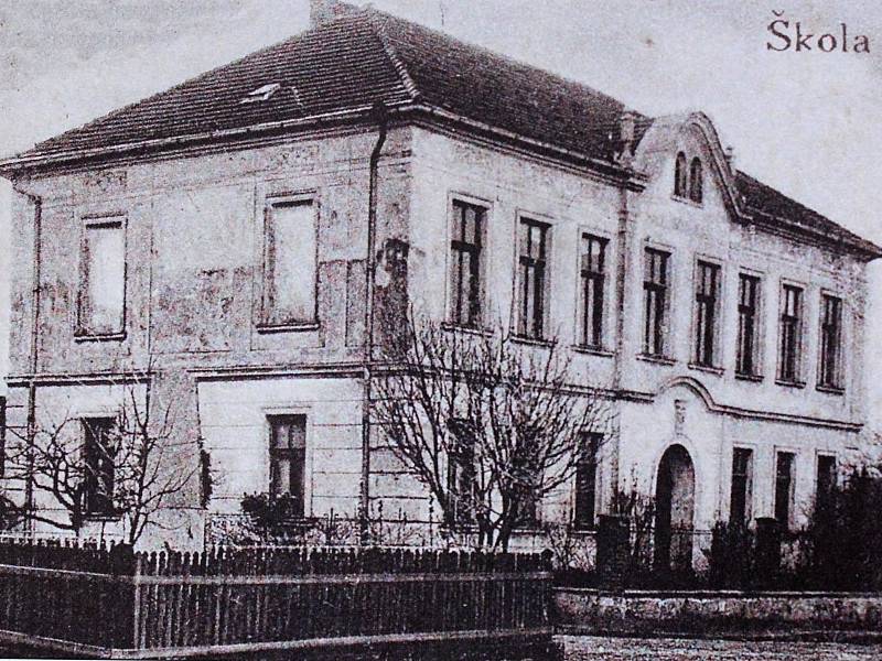 Na fotografii je zachycena pohlednice se školou a památníkem v Hradešíně kolem roku 1927.
