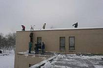 Dobrovolníci odklízeli sníh ze střechy školy