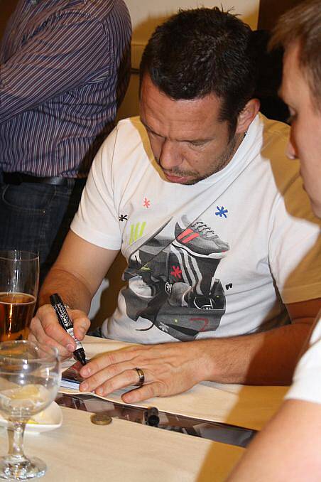 Pavel Horváth podepisuje kartičky.
