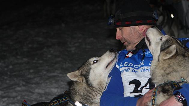 Start úvodní noční etapy 27. ročníku Ledové jízdy musherů od sjezdovky Javor v Peci pod Sněžkou, při které doplňuje posádku psích spřežení běžkař, tažený na laně.