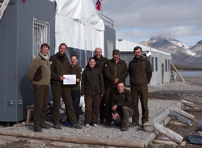 Skupina pracovníků Správy KRNAP před polární stanicí Josefa Svobody v zálivu Petunia. 