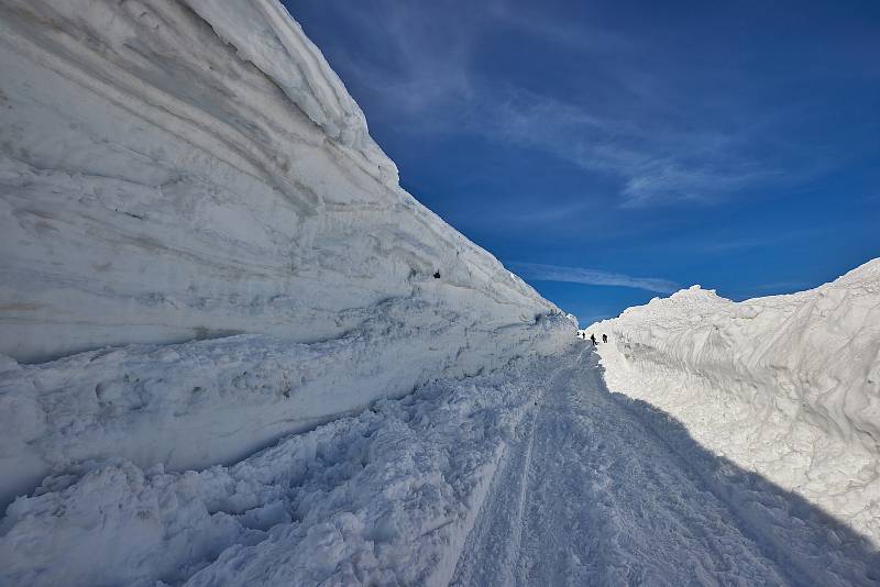 Lidé v neděli vyrazili na turistickou cestu mezi Výrovkou a Luční boudou v Krkonoších. Procházeli kolem mohutných sněhových mantinelů.