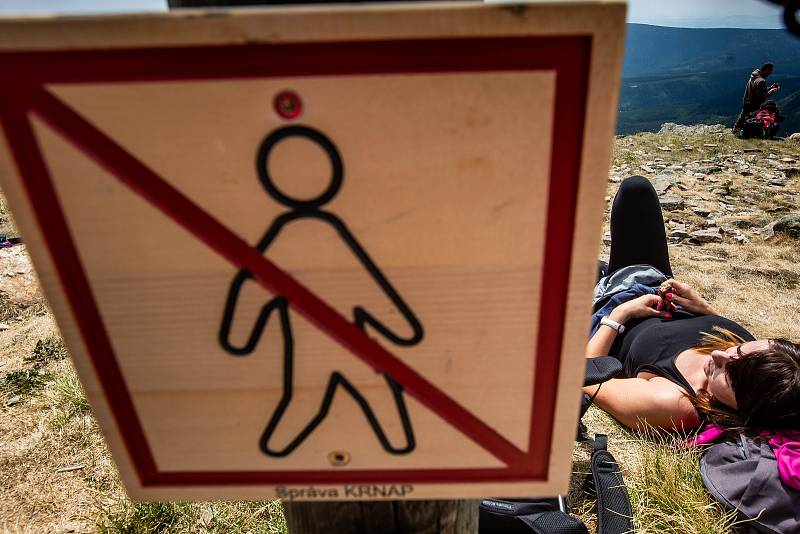 S vysokou návštěvností nejvyšší hory České republiky se pojí i problémy. Stovky turistů porušují zákaz vstupu a piknikují hned za cedulemi se zákazem.