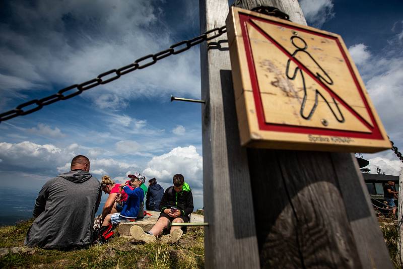 S vysokou návštěvností nejvyšší hory České republiky se pojí i problémy. Stovky turistů porušují zákaz vstupu a piknikují hned za cedulemi se zákazem.