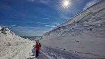 Lidé v neděli vyrazili na turistickou cestu mezi Výrovkou a Luční boudou v Krkonoších. Procházeli kolem mohutných sněhových mantinelů.