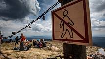 S vysokou návštěvností nejvyšší hory České republiky se pojí i problémy. Stovky turistů porušují zákaz vstupu a piknikují hned za cedulemi se zákazem.