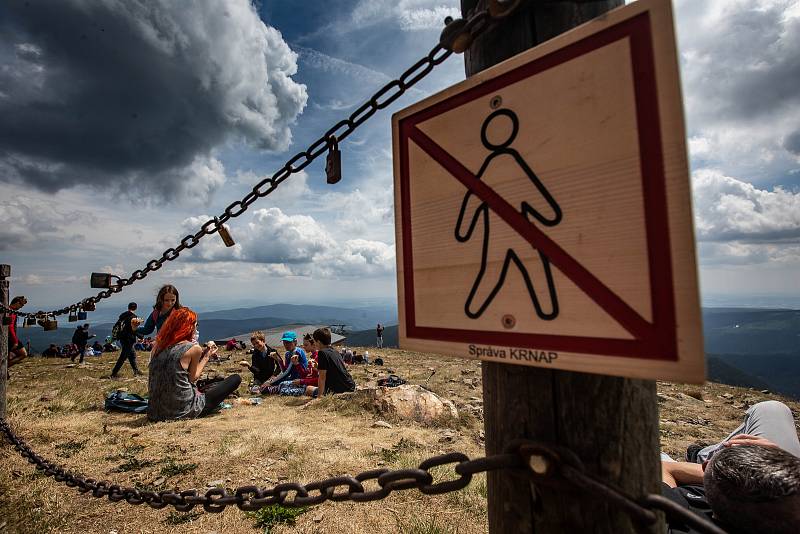 S vysokou návštěvností nejvyšší hory České republiky se pojí i problémy. Stovky turistů porušují zákaz vstupu a piknikují hned za cedulemi se zákazem.