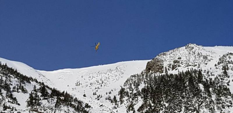 Přílet vrtulníku do střední části pro vyzvednutí staršího skialpinisty.
