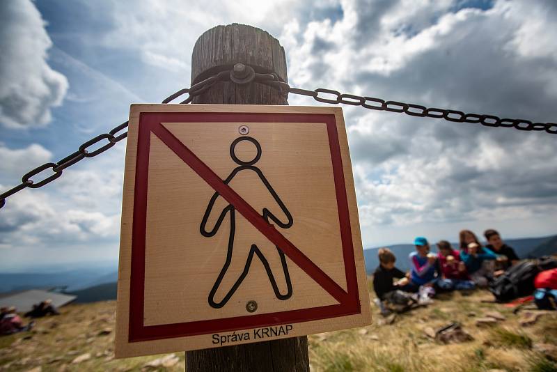 S vysokou návštěvností nejvyšší hory České republiky se pojí i problémy. Stovky turistů porušují zákaz vstupu a piknikují hned za cedulemi se zákazem.