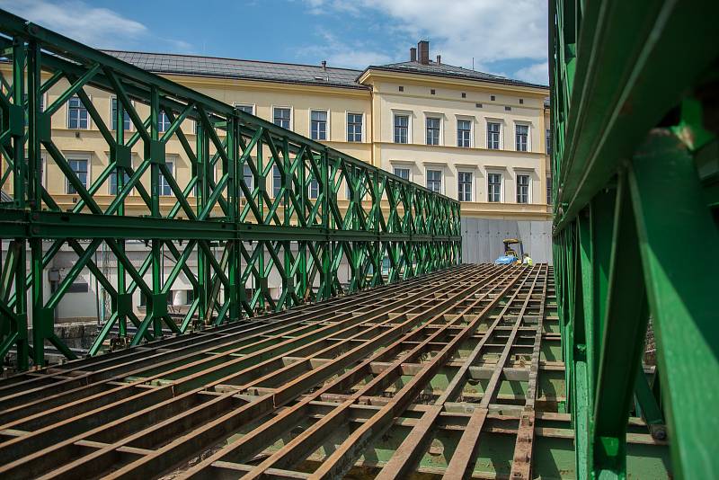 Dělníci připravují mostní provizorium přes říčku Čistou, po kterém budou jezdit auta během opravy památkově chráněného mostu v centru Hostinného.