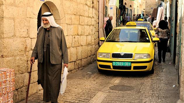 Město Betlém. Tradiční palestinský oděv s nastupující generací postupně mizí. Škoda je velice oblíbený automobil v Palestině.