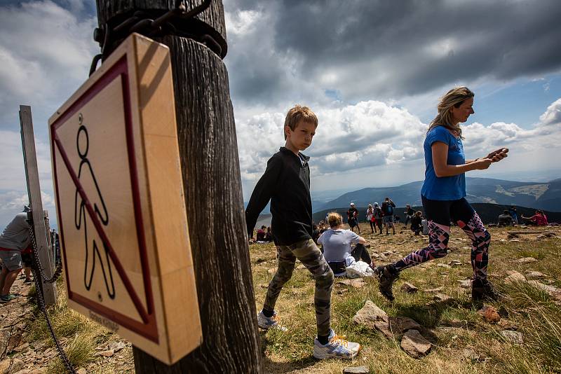 S vysokou návštěvností nejvyšší hory České republiky se pojí i problémy. Stovky turistů porušují zákaz vstupu a piknikují hned za cedulemi se zákazem.