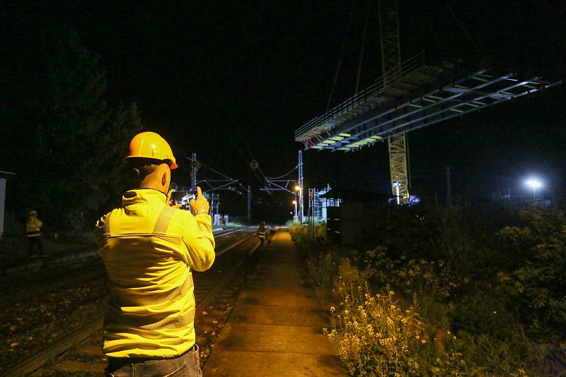 Z nočního usazování mostní konstrukce nad železniční tratí při výstavbě obchvatu Církvice.