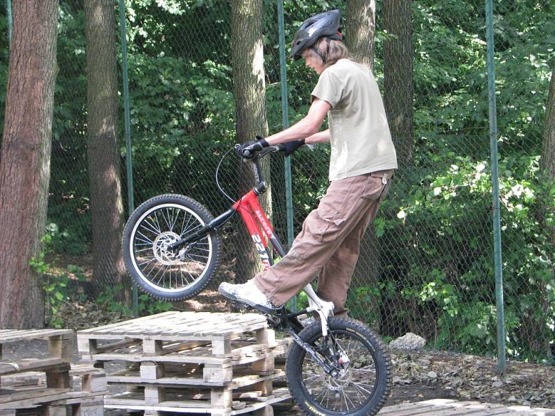 Přejezd přes lávku rybníka na kole v Opatovicích I. Exhibice biketrialistů.