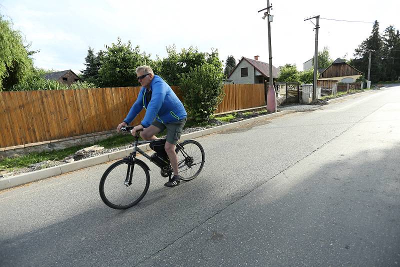 Muž na kole v Úmoníně na Kutnohorsku. V obci bylo na některých místech opět zavedeno nošení roušek