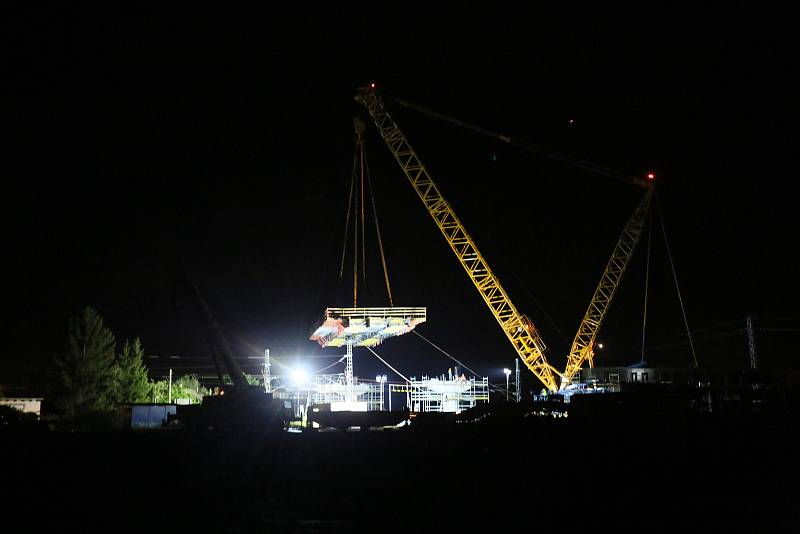 Z nočního usazování mostní konstrukce nad železniční tratí při výstavbě obchvatu Církvice.