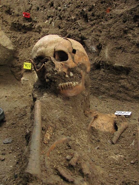 Čtyři desítky nalezených koster v sousedství hřbitovní zdi v Raspenavě se musí nafotit, změřit, zakreslit a opatrně vyjmout k analýze. Na snímku hlavní archeolog Severočeského muzea v Liberci Petr Brestovanský.