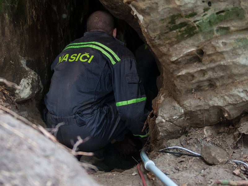 V lese u části Obce Vyskeř - Skalany snaží hasiči a záchranáři již šestým dnem vyprostit psa, který uvízl v liščí noře mezi skalami.