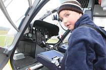 Děti na návštěvě u letecké záchranné služby na letišti v Liberci. Kabinu pilota vrtulníku si prohlíží Jakub Kříž.