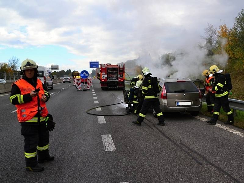 Požár osobního auta na frekventované silnici.