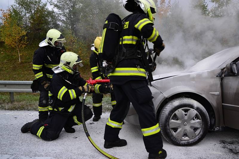 Požár osobního auta na frekventované silnici.