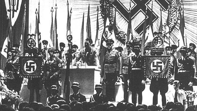 Hitlerův náměstek Rudolf Hess přijímá na libereckém výstavišti vlajku od Konrada Henleina.
