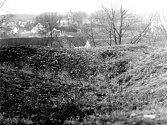 Pohled na travou porostlé zbytky zdí lásenické tvrze. Foceno na  podzim 1983