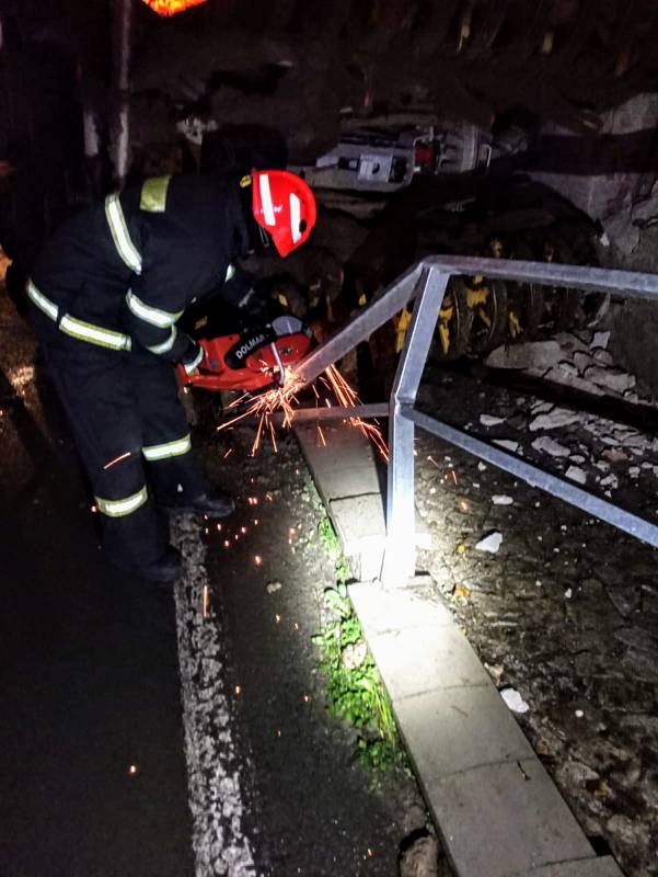 Hasiči v Dešné několik hodin vyprošťovali traktor s cisternou s kejdou, která se převrátila na dům.