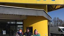 Dobrovolníci ze skupiny Roušky lidem rozdávají roušky před jindřichohradeckými supermarkety.
