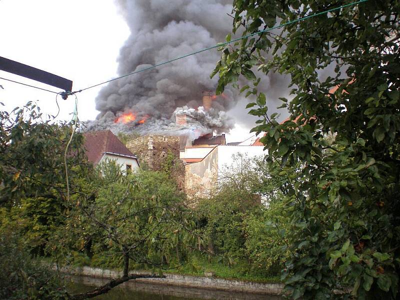 Pohled na plameny šlehající ze střechy pivovaru v Jindřichově Hradci, který 7. září zachvátil požár. 