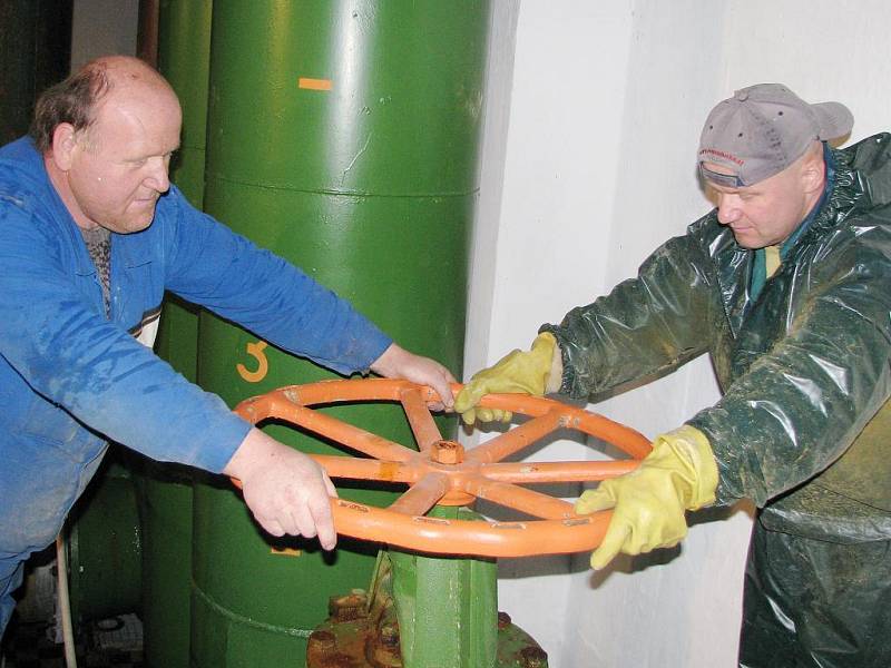 Pracovníci Vodovodů a kanalizací Zdeněk Janda a Petr Pospíšil napouštějí vodu do vyčištěné nádrže. 
