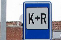 Nová dopravní značka pro parkování K+R. Zkratka vychází z anglického Kiss and Ride, v překladu doslova Polib a jeď. Vyznačuje prostor pro rychlý nástup či výstup osob. Ilustrační foto.