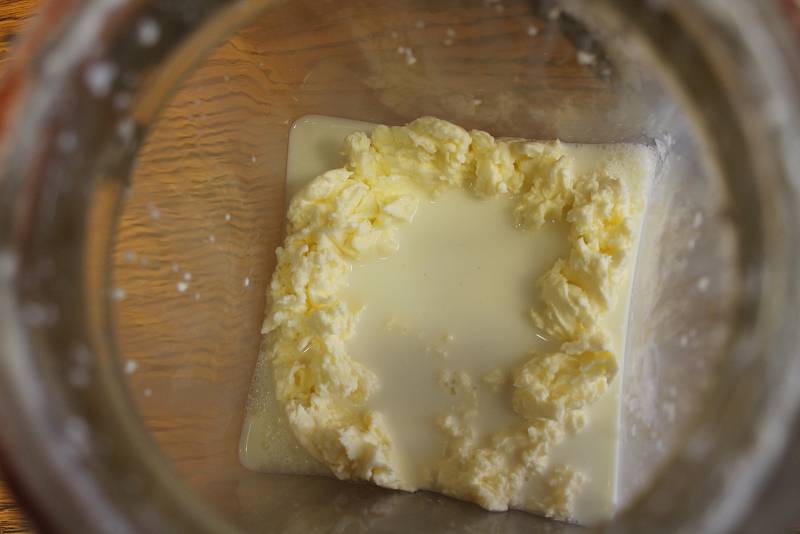Celkem půl hodiny šlehání přineslo očekávaný výsledek. V máselnici zůstala kompaktní část másla, od kterého se oddělilo voňavé podmáslí.