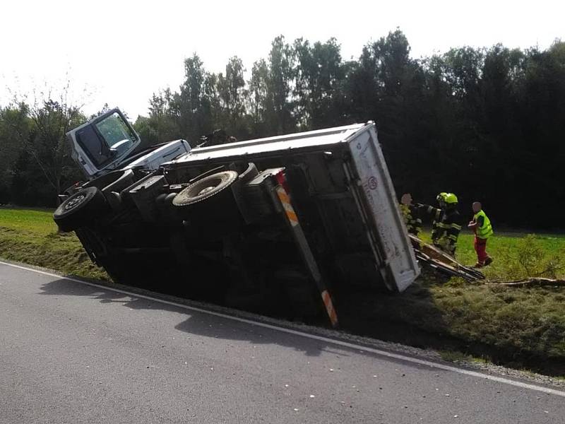 Při nehodě nákladního auta u Nové Bystřice vypadl z korby bagr.