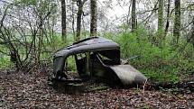 Pohled na vrak starého auta ukrytý v lese u Jindřichova Hradce.