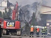 Za pomoci speciálního bagru začali včera hasiči rozebírat vyhořelou skladovou halu na pražené ořechy a sušené ovoce v Horní Cerekvi na Pelhřimovsku, kterou v neděli zasáhl požár.