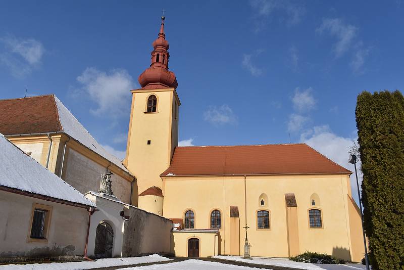 Na návsi se nachází i kostel, který je propojený se zámkem.