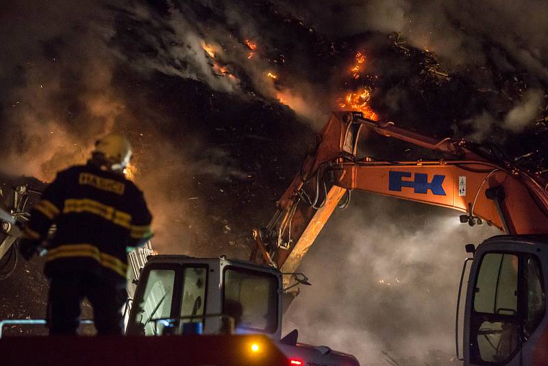 Na okraji obce Nová Cerekev na Pelhřimovsku mají hasiči plné ruce práce s požárem uskladněné dřevotřískové drti.