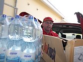 Zaměstnanec supermarketu Lubomír Mokrý ukládá darované potraviny do přistavené charitní dodávky. 