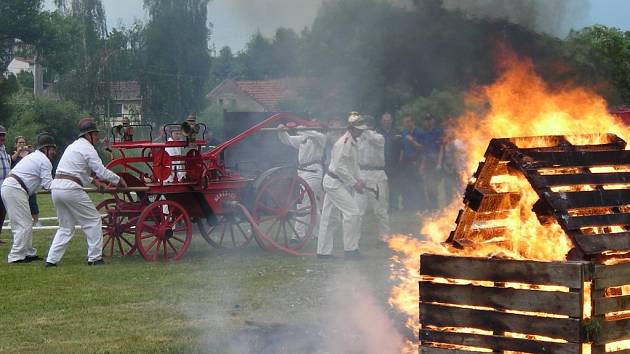 Dobrovolní hasiči s historickou stříkačkou.