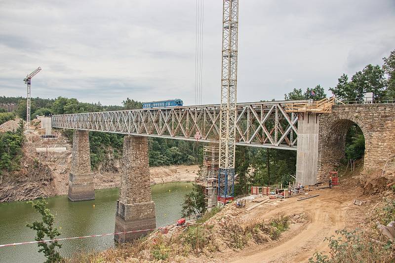 U Červené nad Vltavou na trati z Tábora do Písku pokračuje příprava na výstavbu mostu přes Orlickou přehradu. Pracuje se na pilířích a opěrách. Rozpětí oblouku bude 156 metrů, délka přemostění 300 metrů.