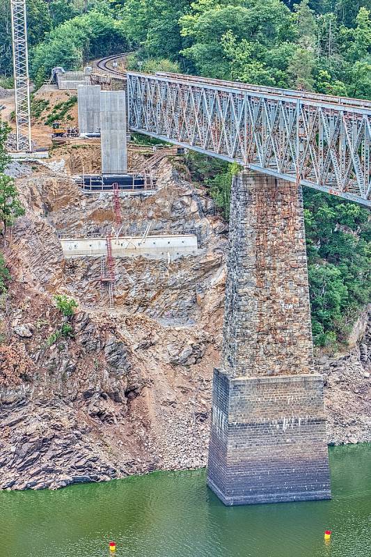 U Červené nad Vltavou na trati z Tábora do Písku pokračuje příprava na výstavbu mostu přes Orlickou přehradu. Pracuje se na pilířích a opěrách. Rozpětí oblouku bude 156 metrů, délka přemostění 300 metrů.
