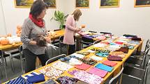 Prachatičtí dobrovolníci vybírají panenky a látky na jejich nové oblečky.