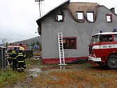 Lenorští hasiči u vyhořelého domu drží hlídku během celého úterka.